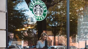 Ein Starbucks Coffee Schild an einem Glasfenster.