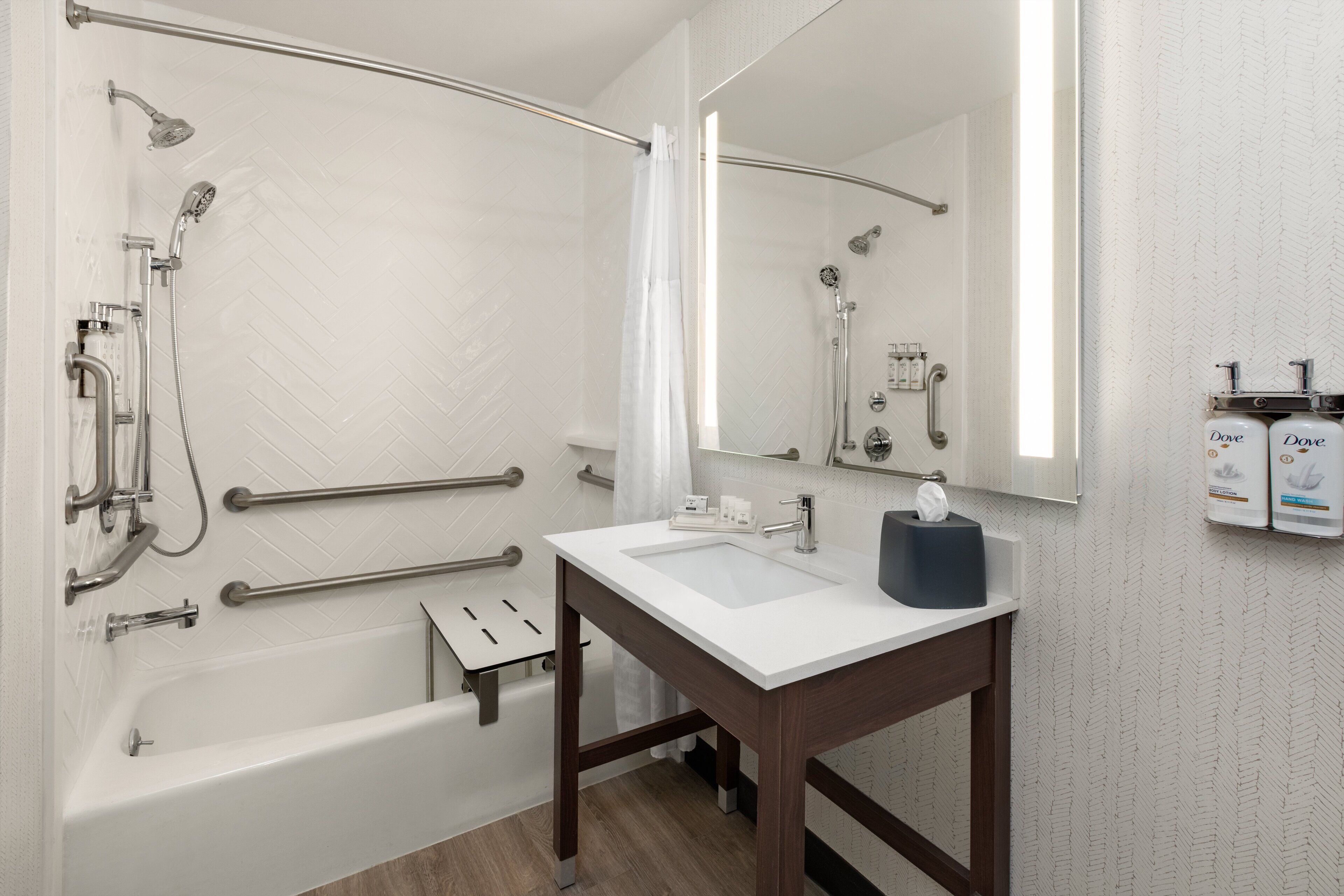 Une salle de bain moderne équipée d’une baignoire, d’une douche et d’un meuble-lavabo avec un miroir.
