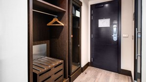 Un baño moderno con un mueble de tocador de madera oscura, un perchero para toallas y un box de ducha de vidrio.