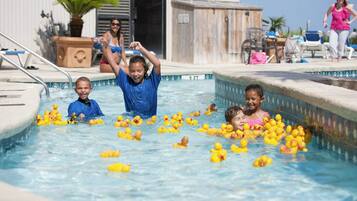 Una piscina con niños y patitos de goma.