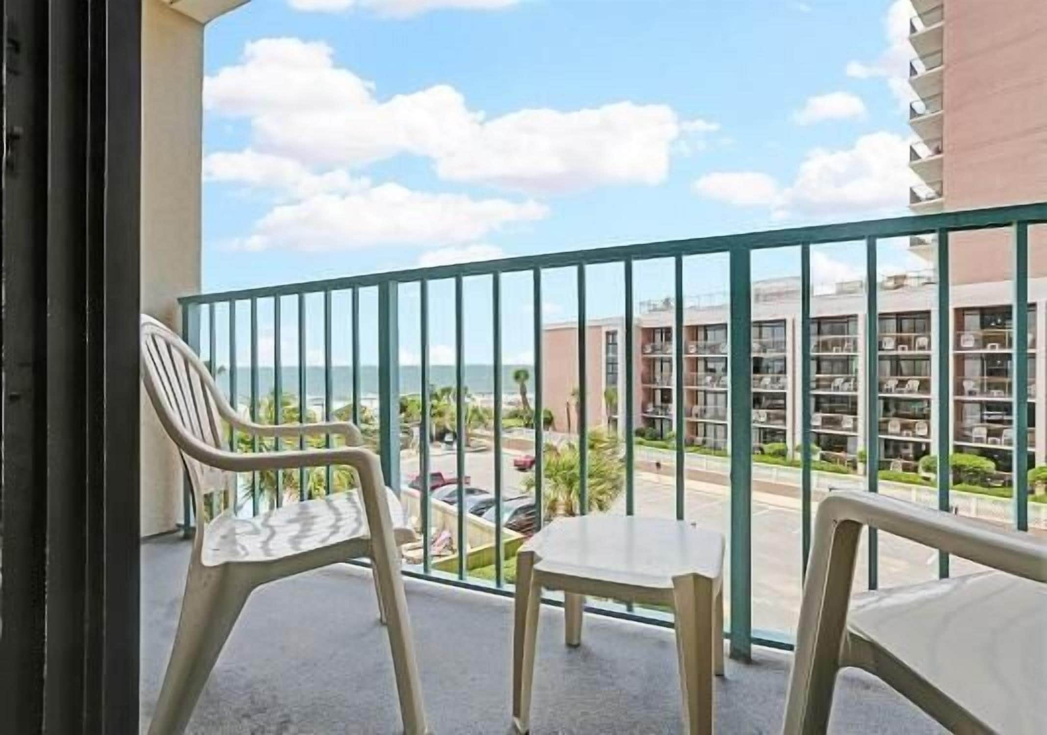 A balcony with a view of a building complex and a road.