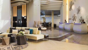 A modern lobby with a sofa, coffee table, and decorative elements. - Renaissance Santo Domingo Jaragua Hotel & Casino (Santo Domingo)