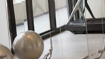 A gym with exercise equipment, including a cable machine and a treadmill.