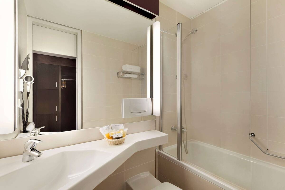 Une salle de bain moderne avec un grand lavabo, une douche à l’italienne et un porte-serviettes.