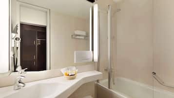A modern bathroom with a large sink, a glass shower enclosure, and a towel rack.