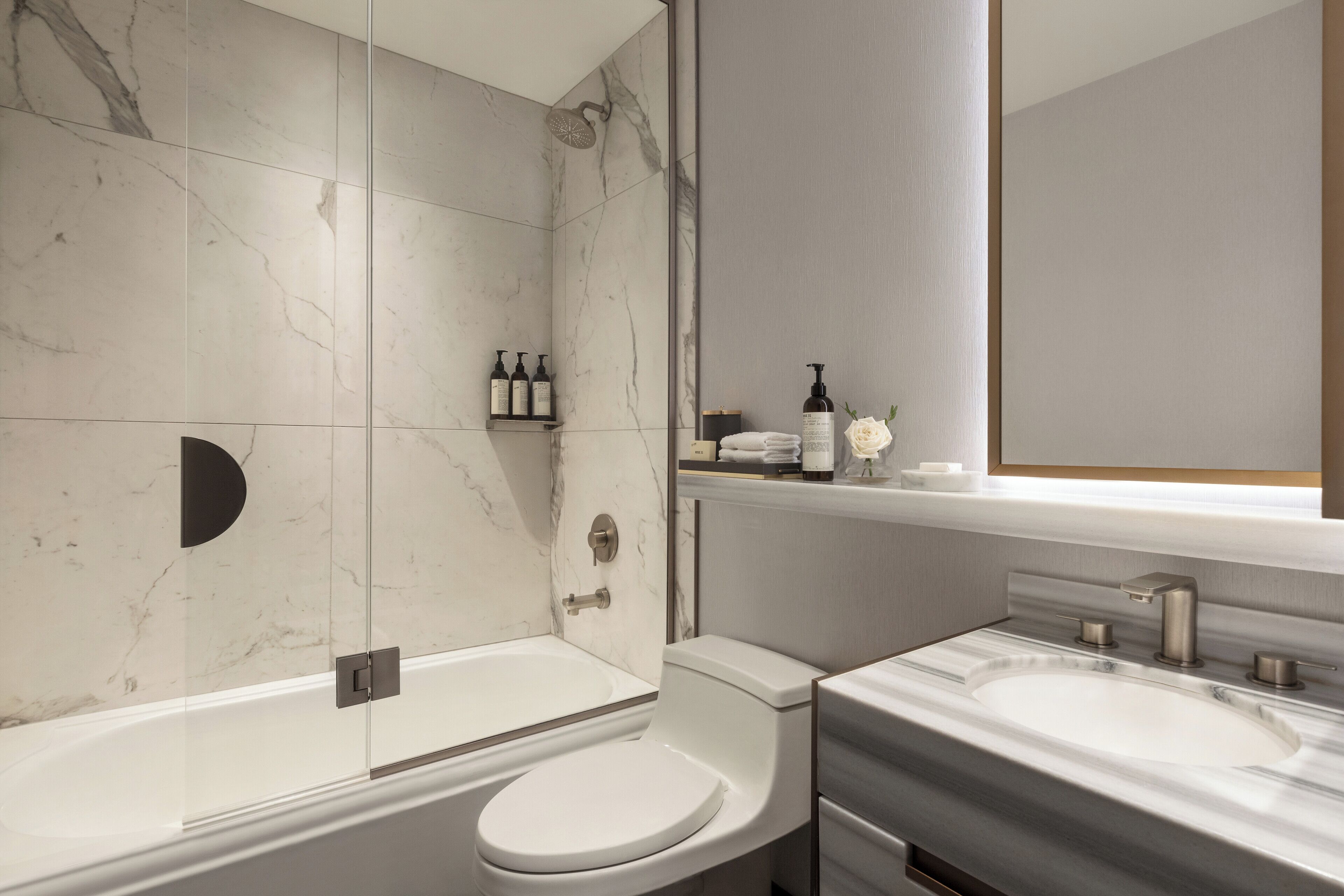 A modern bathroom with a bathtub, toilet, and sink.