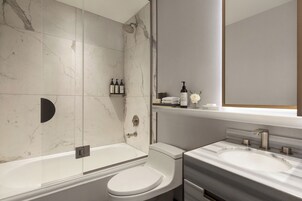 A modern bathroom with a bathtub, toilet, and sink.