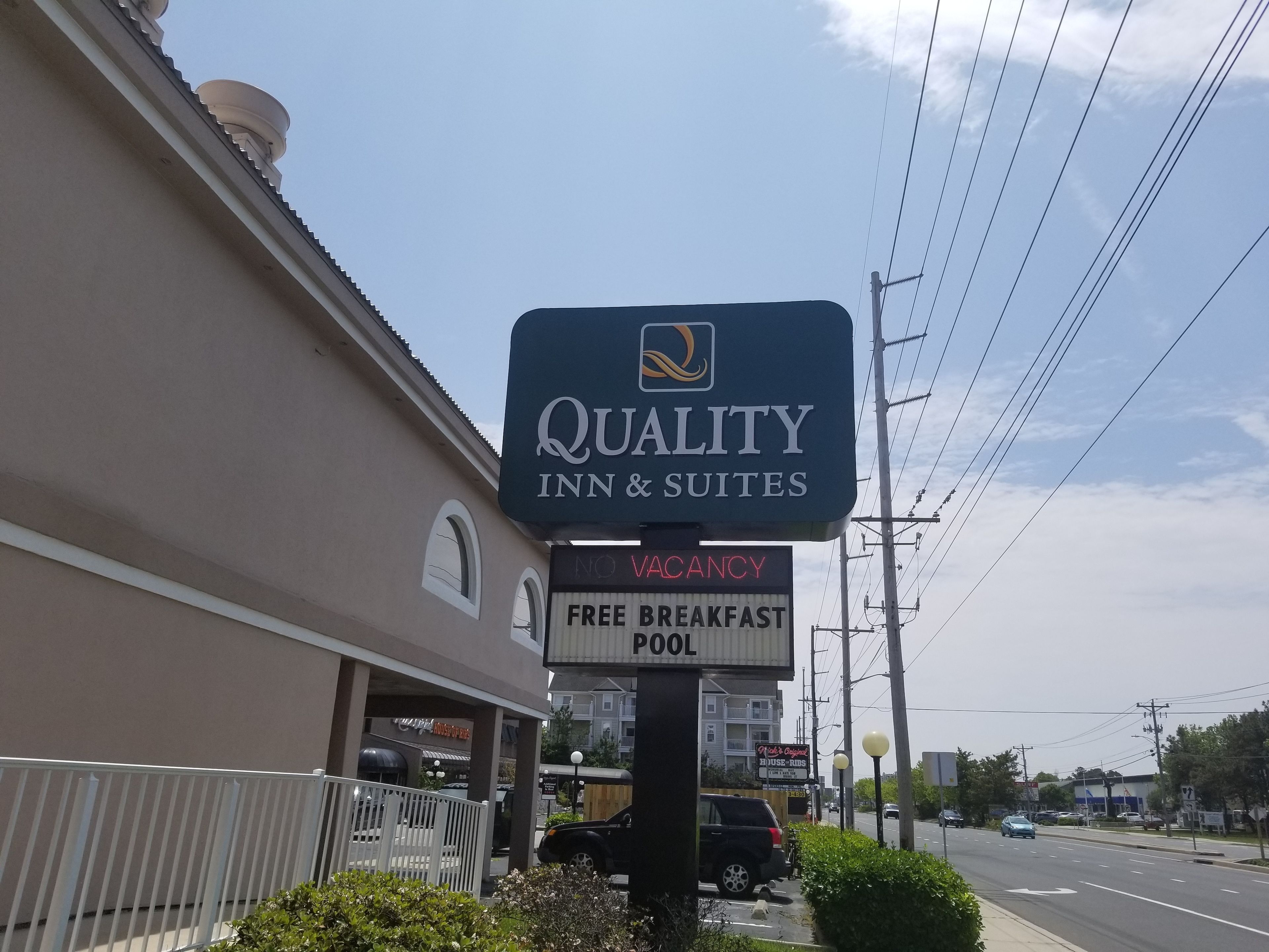 Une enseigne indiquant que l’hôtel Quality Inn & Suites est complet, qu’il offre un petit-déjeuner gratuit et qu’il dispose d’une piscine.