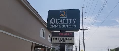 Schild des Quality Inn & Suites mit der Aufschrift: keine freien Zimmer, kostenloses Frühstück und Pool.
