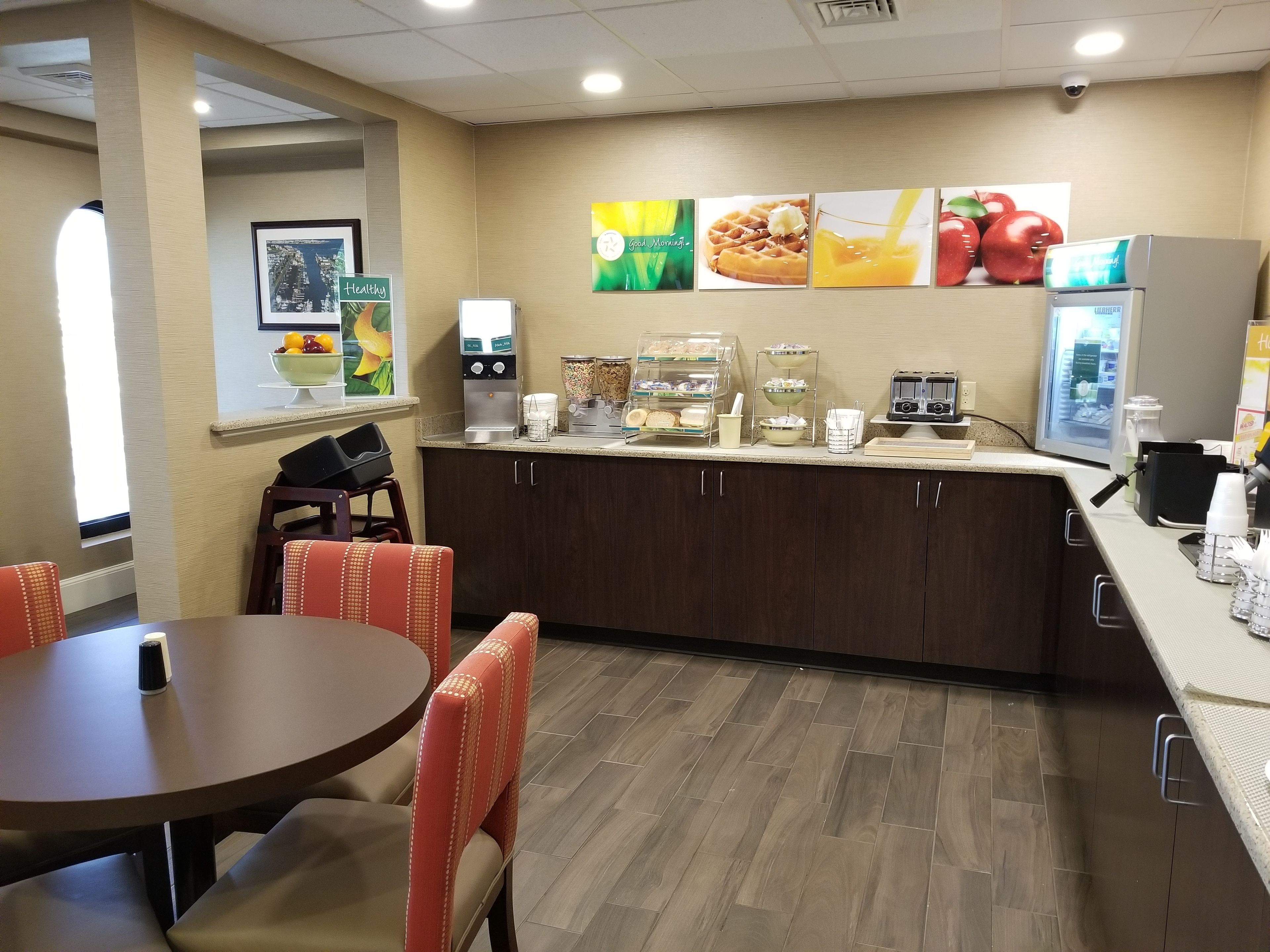 Un'area colazione con un bancone, posti a sedere e una macchina da caffè.