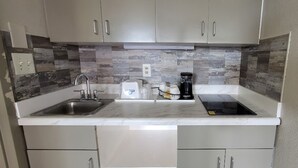 A modern kitchen with two sinks, a coffee maker, and a built-in oven. - Days Inn by Wyndham Conway (Conway)