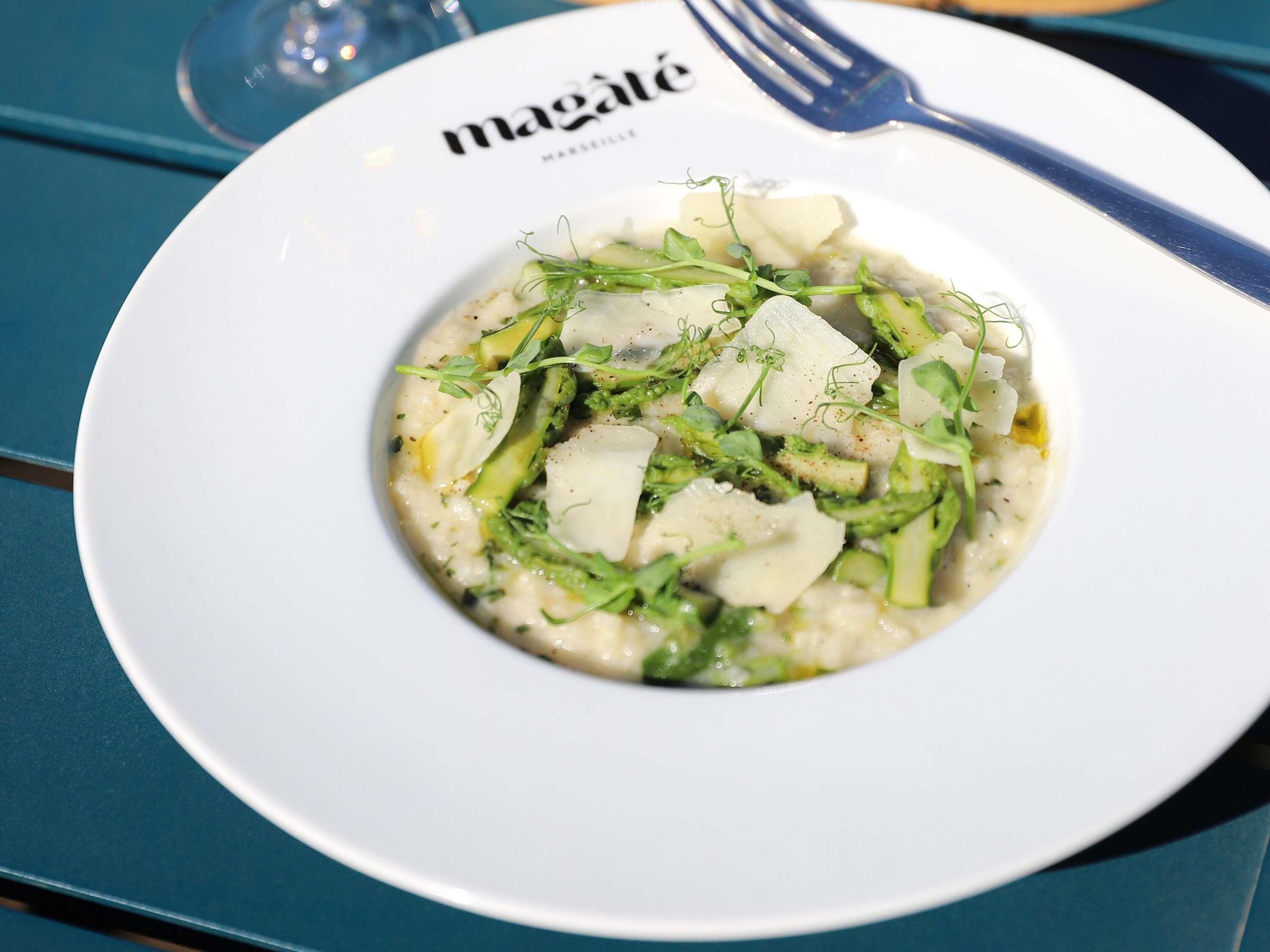 Plat de menjar amb plat blanc i forquilla damunt d'un taulell blau.