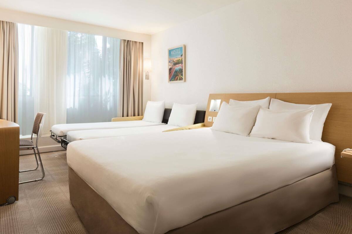 Una habitación de hotel con una cama grande, un escritorio y una silla.