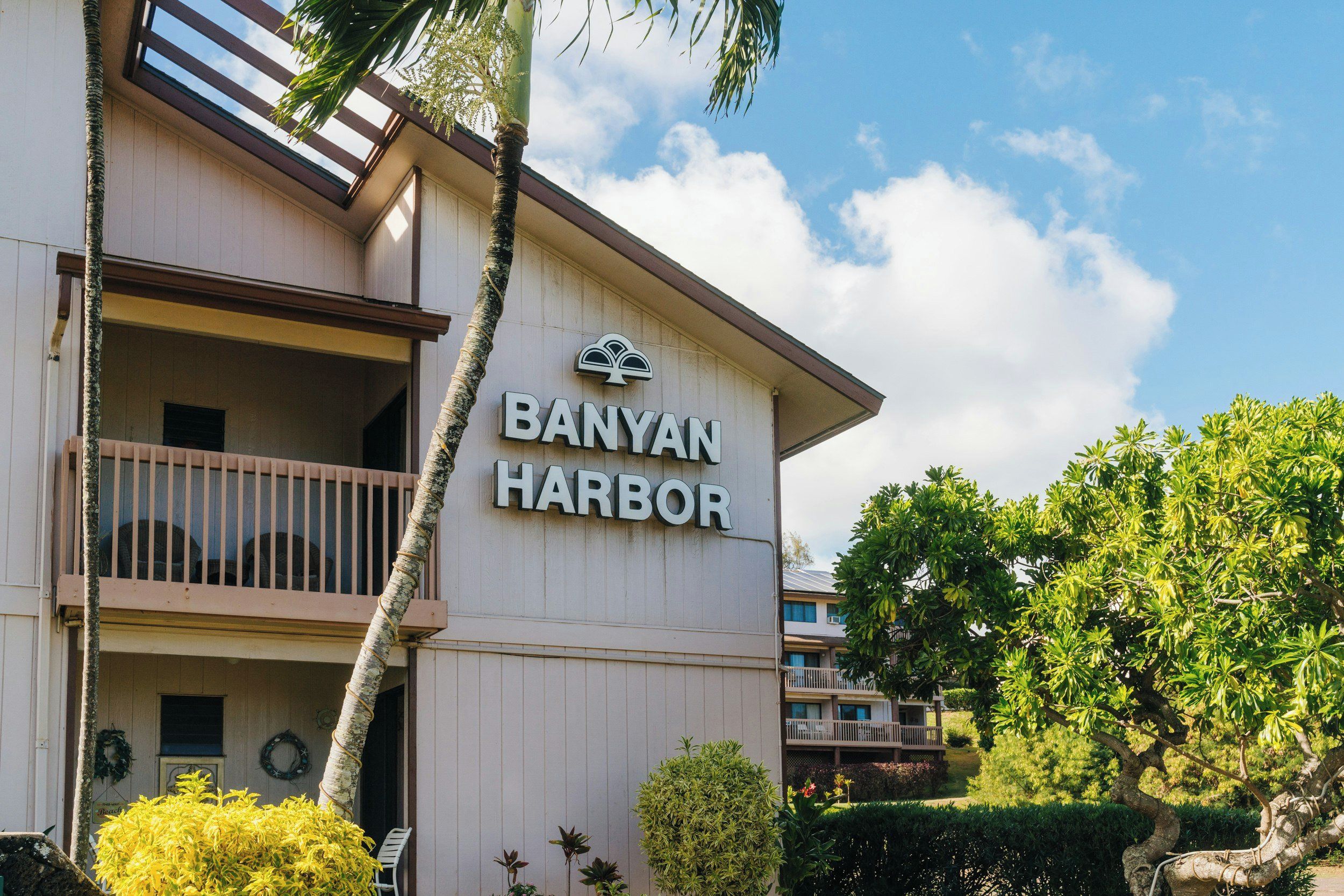 Un hotel llamado 'BANYAN HARBOR' con un balcón y un letrero.