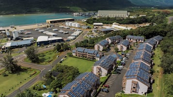 A solar-powered residential area with multiple houses, a large industrial building, and a marina.
