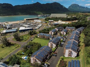 A solar-powered residential area with multiple houses, a large industrial building, and a marina. - Banyan Harbor Resort (Lihue)
