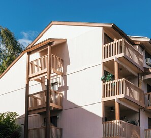 A multi-story building with balconies, a visible window, and a clear sky. - Banyan Harbor Resort (Lihue)