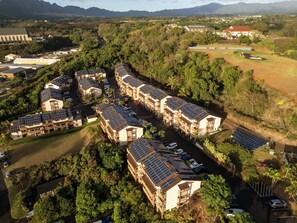 A residential area with multiple buildings featuring solar panels on the roofs. - Banyan Harbor Resort (Lihue)
