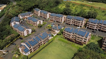 A residential complex with multiple buildings, each featuring solar panels on the roofs.