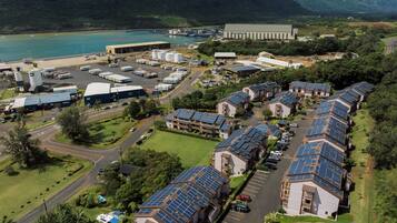 A solar-powered residential area with multiple houses, a large industrial building, and a marina.