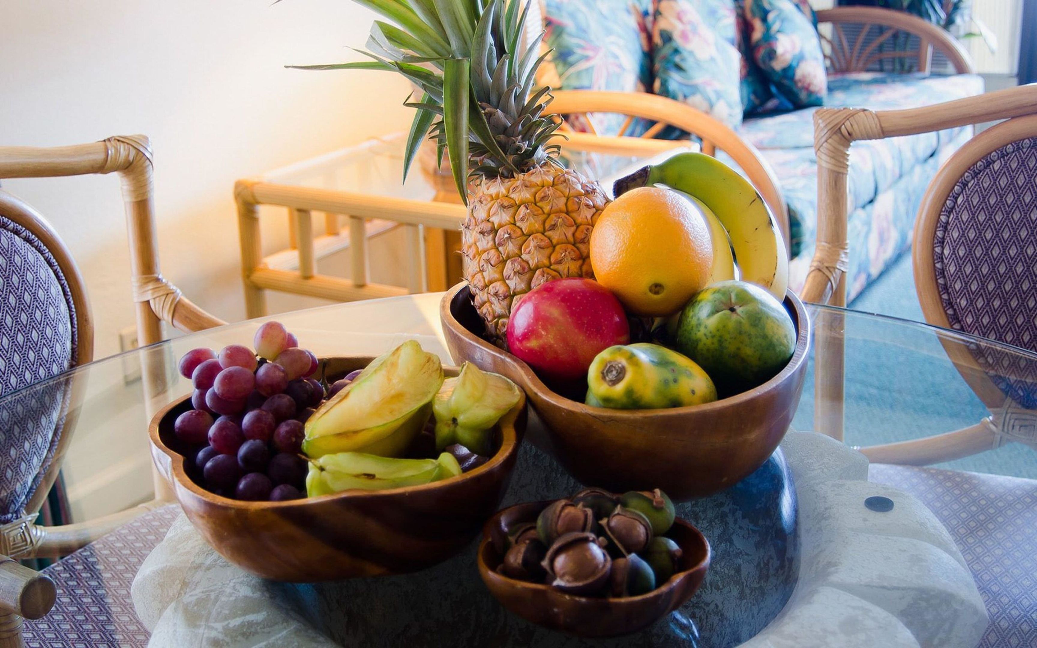 A dining table with fruit bowls and a pineapple.