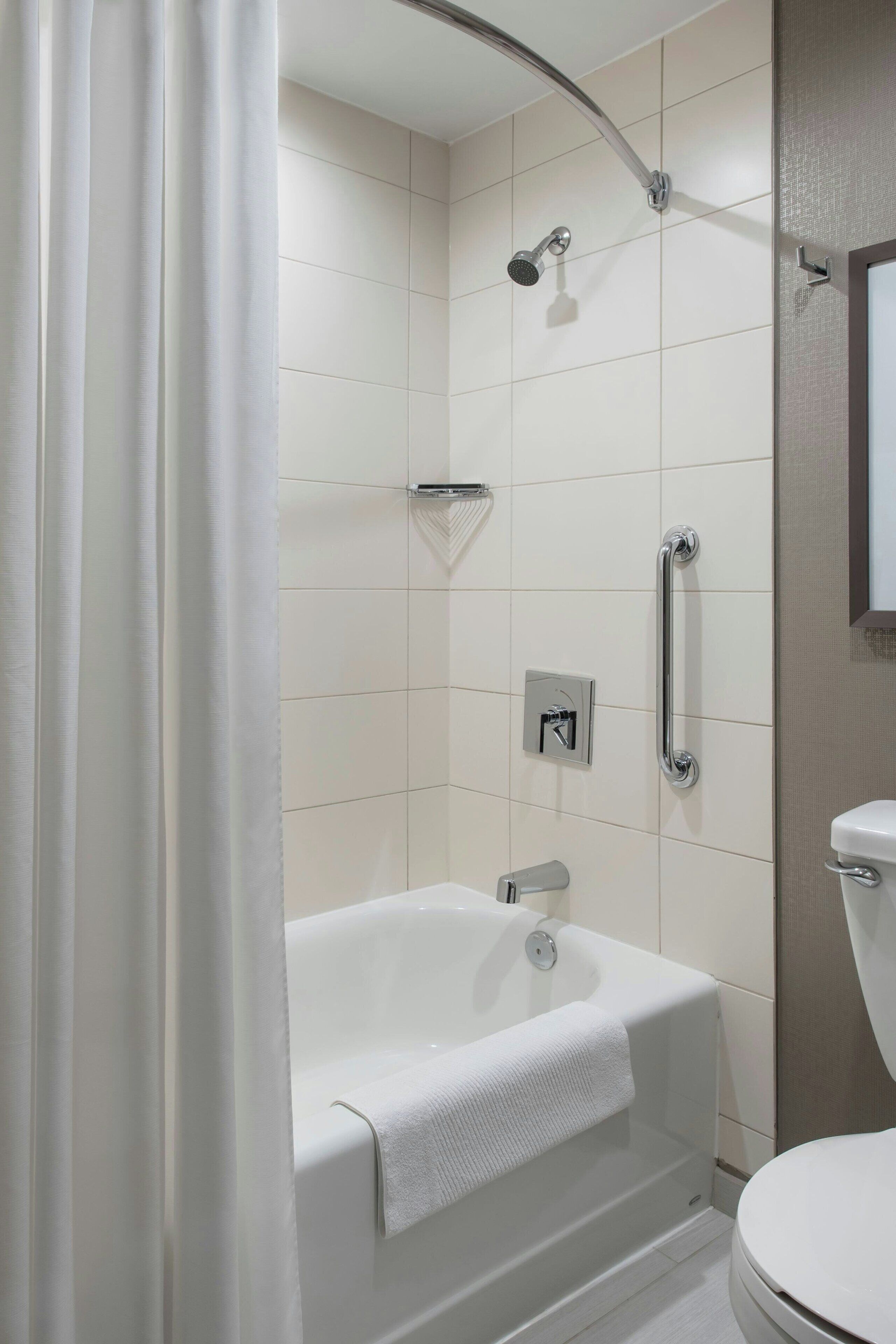 Ein modernes Badezimmer mit Badewanne, Dusche und Toilette.