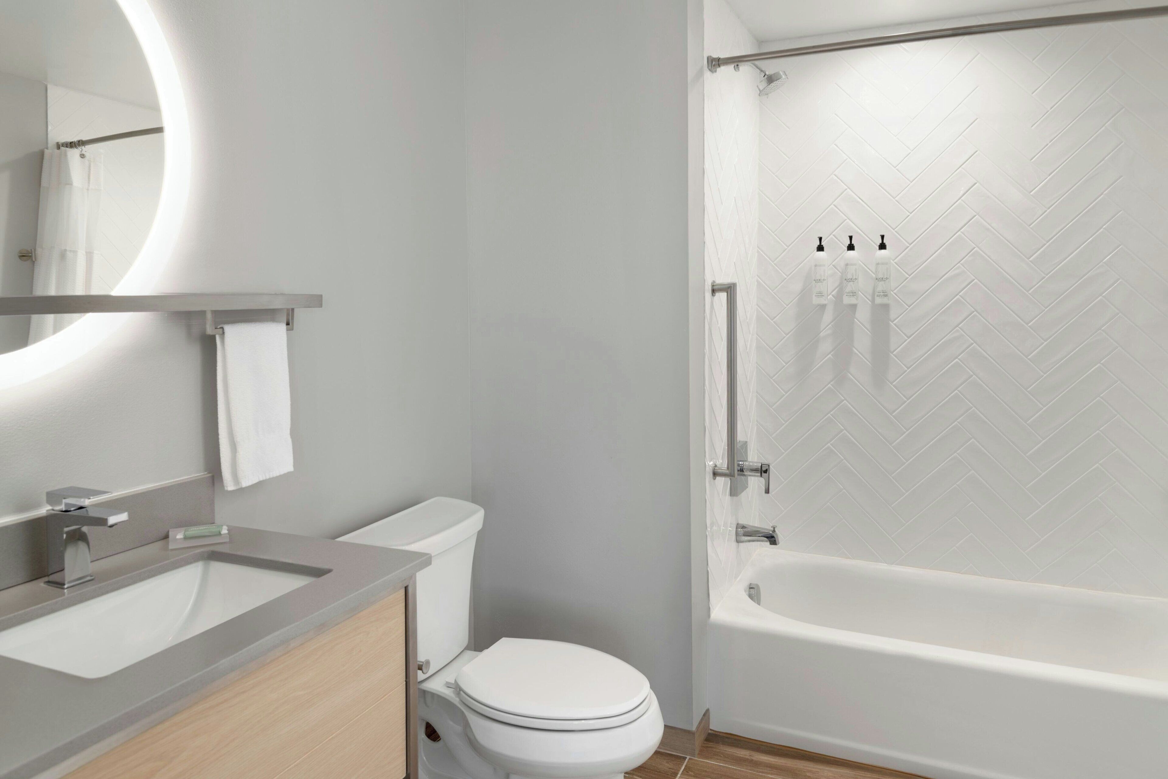 A modern bathroom with a toilet, sink, and bathtub.