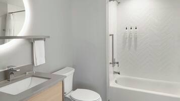 A modern bathroom with a toilet, sink, and bathtub.
