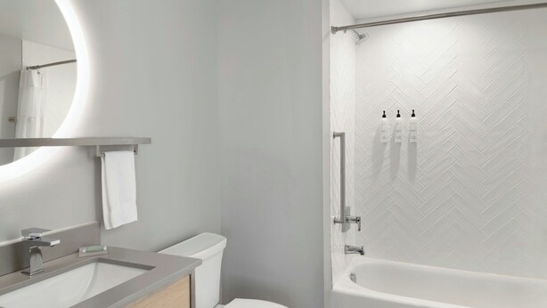 Un baño moderno con inodoro, lavamanos y bañera.