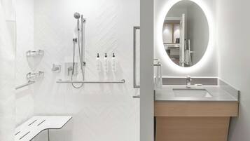 A modern bathroom with a shower, a sink, and a mirror.