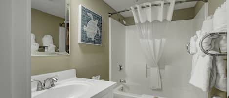 Un baño con lavamanos, inodoro y bañera.