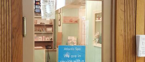 Der Eingang zum Atlantis Spa mit einem Schild, das die Verfügbarkeit von Behandlungen anzeigt.