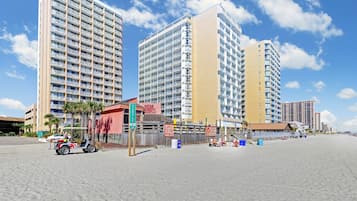 Na praia, espreguiçadeiras, guarda-sóis, toalhas de praia