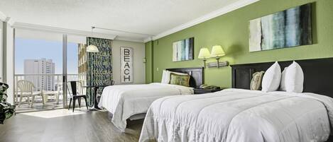 Une chambre d’hôtel avec deux lits, un balcon avec des chaises et une vue sur les immeubles.