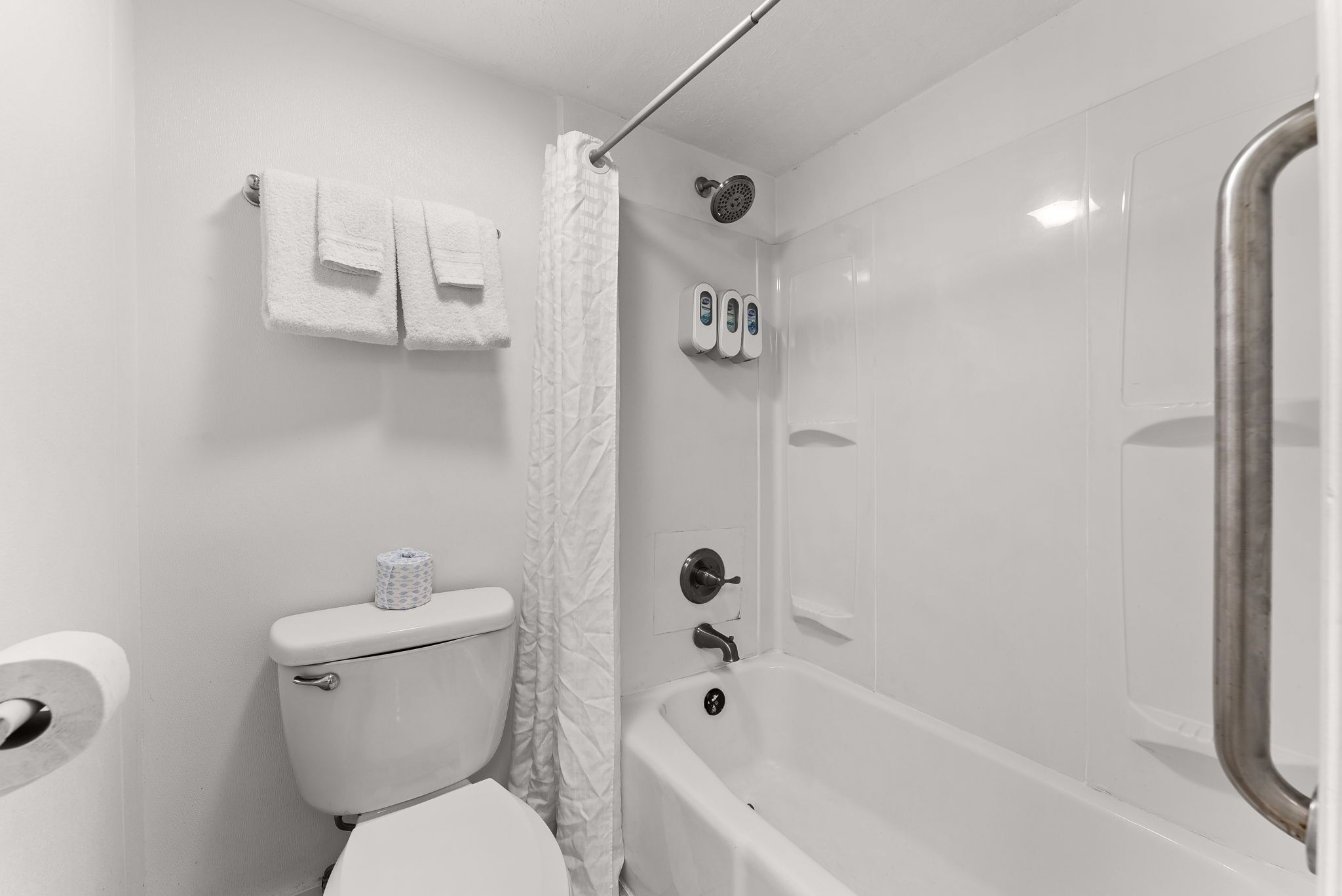 A bathroom with a toilet, a shower, and a bathtub.