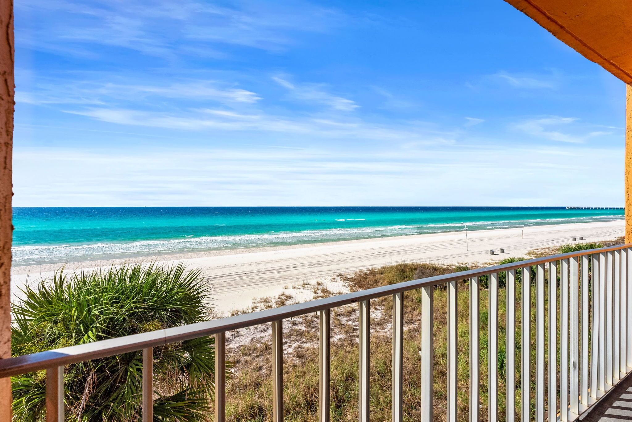 A balcony with a view of a beach and ocean.