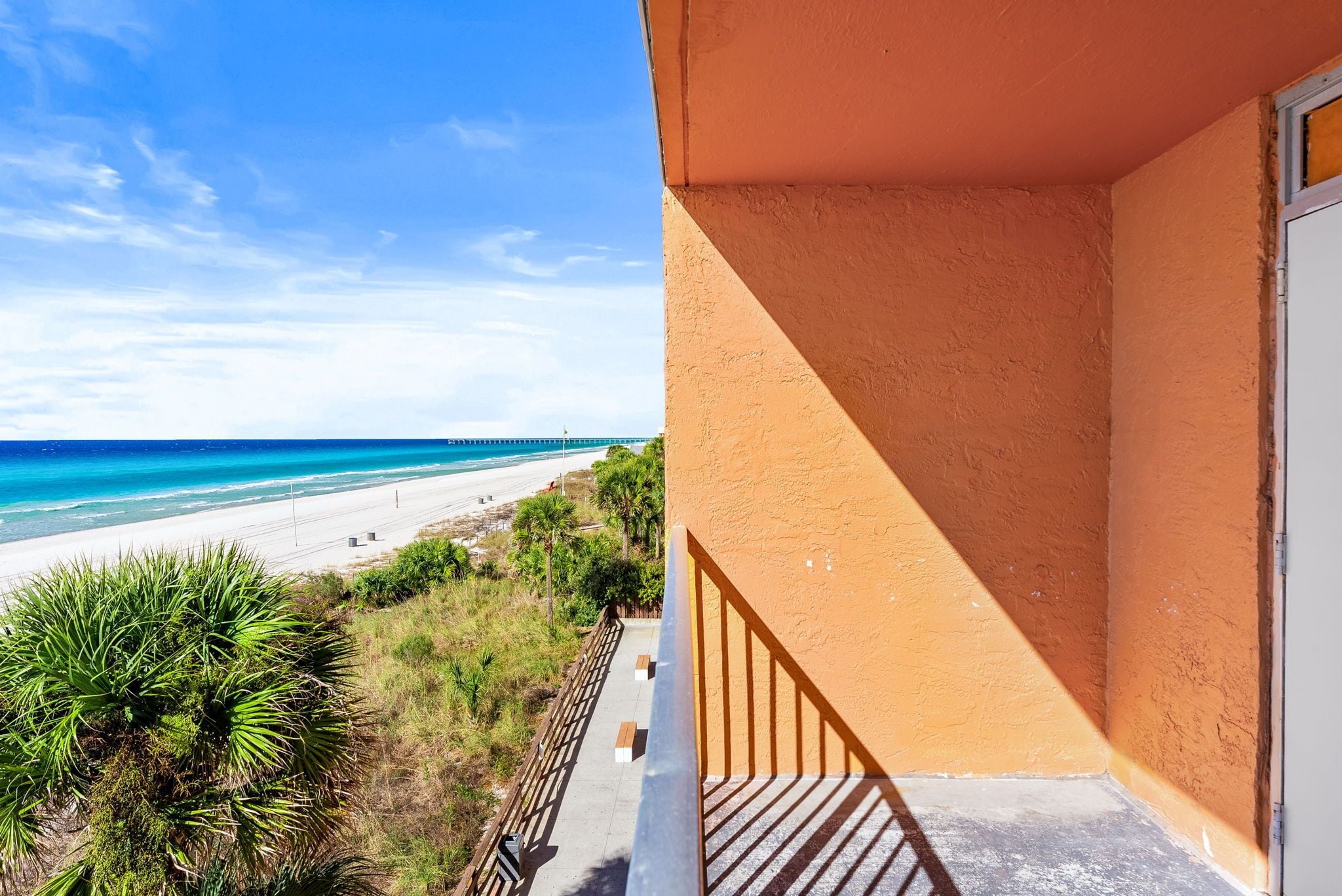 A balcony with a view of a beach and ocean.