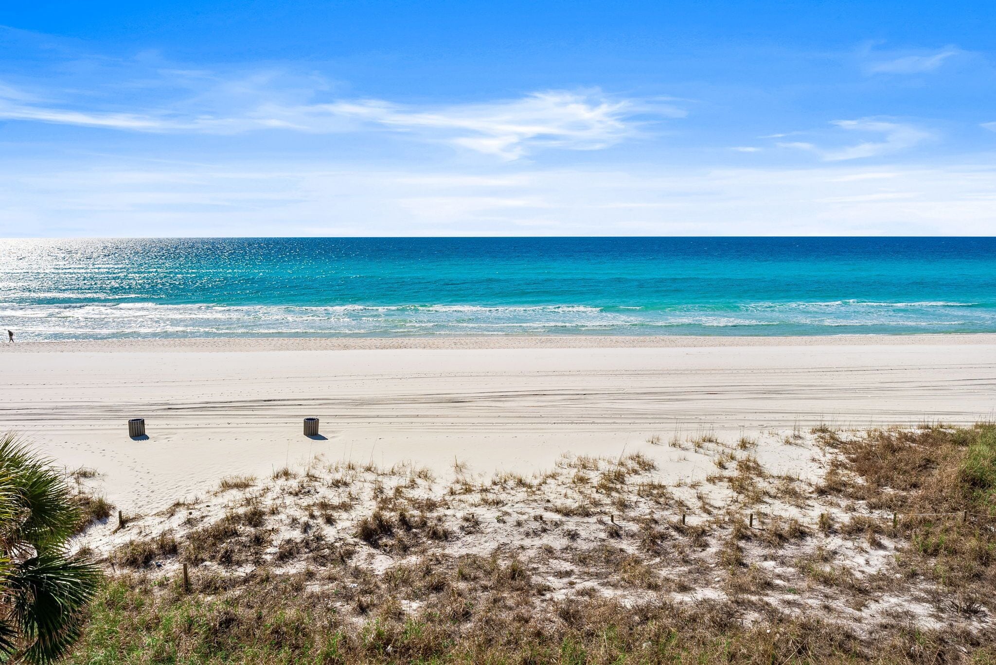 Una playa con cielo despejado, mar tranquilo y orilla de arena.