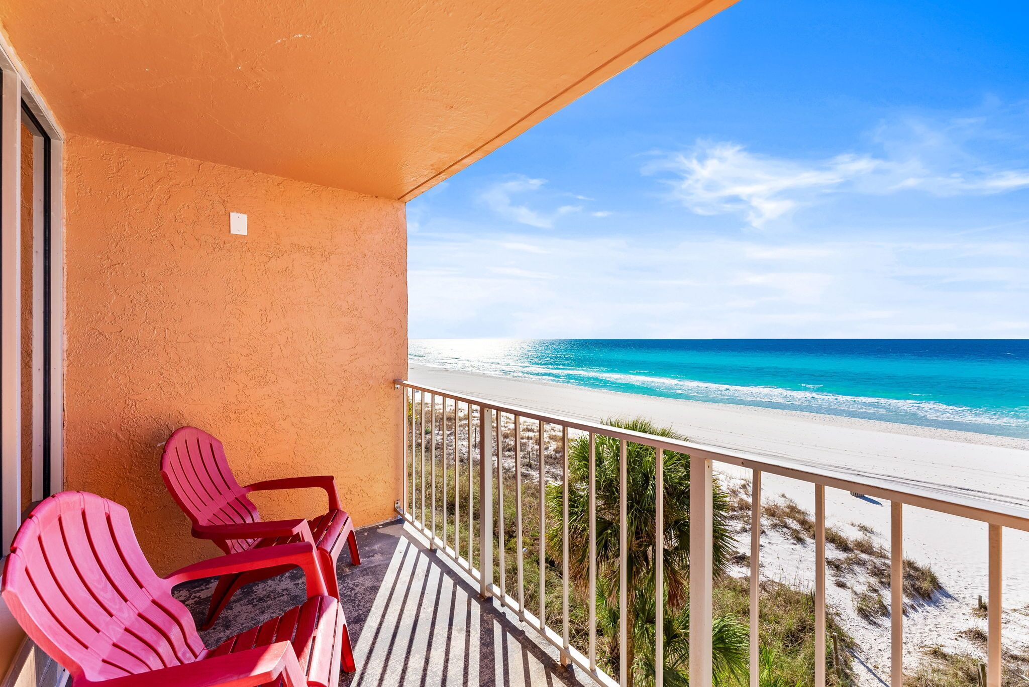 A balcony with a view of a beach and ocean.