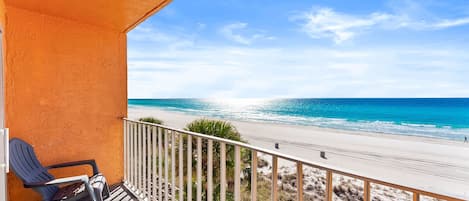 Ein Balkon mit Blick auf Strand und Meer.