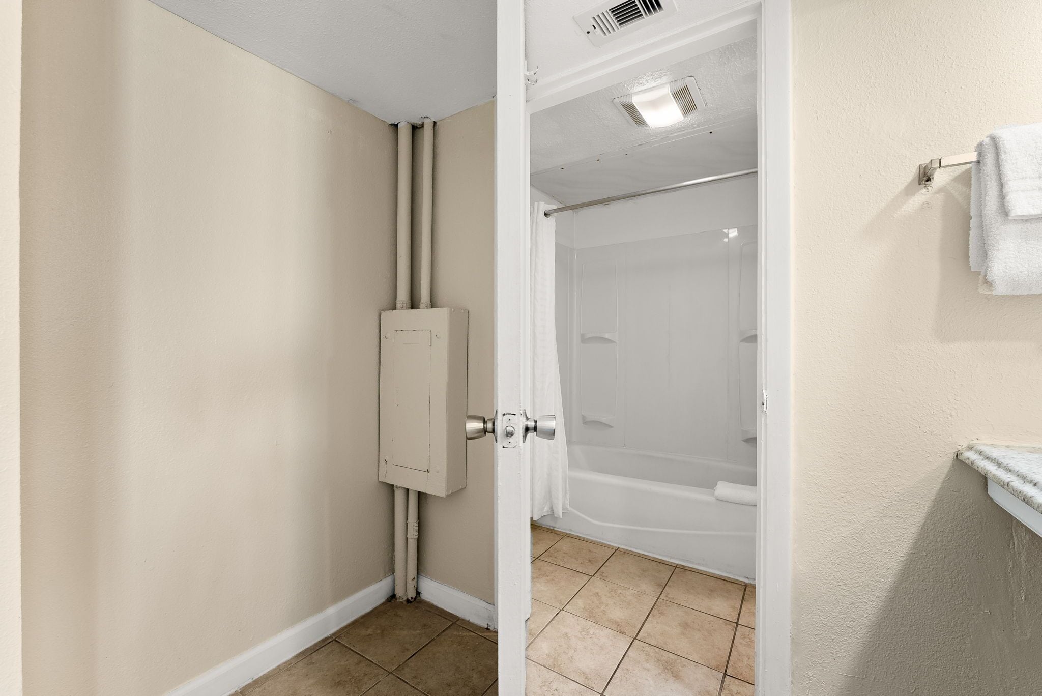 A bathroom with a shower, a toilet, and a towel rack.
