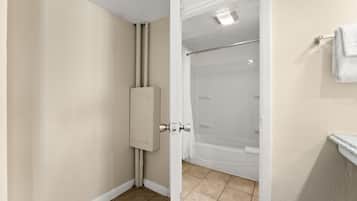 A bathroom with a shower, a toilet, and a towel rack.