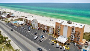A hotel with a parking lot, beach view, and a road in the foreground. - Seahaven Beach Hotel (Panama City Beach)