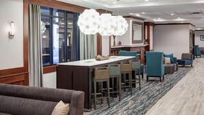 A hotel lobby with a bar area, seating, and a large window. - Hampton Inn St. Louis-Downtown (At the Gateway Arch) (St. Louis)