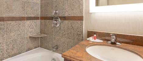 A bathroom with a bathtub, a sink, and a mirror.