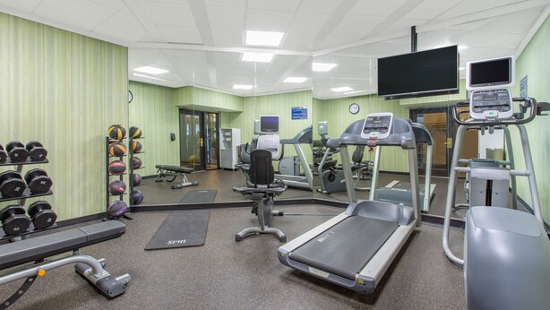 A gym with treadmills, elliptical machines, free weights, and a mirrored wall. - Days Inn by Wyndham Lanham Washington DC (Lanham)
