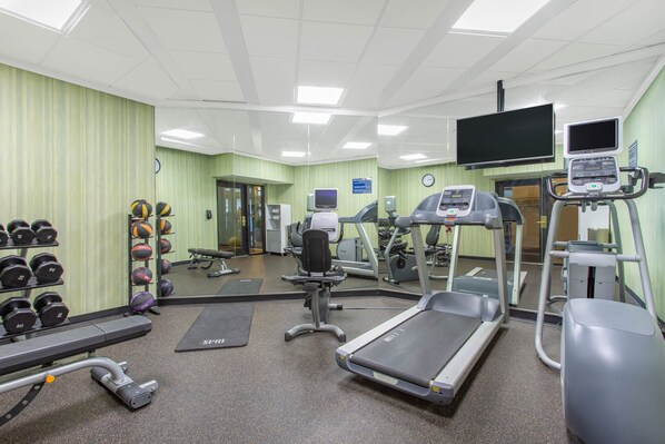 A gym with treadmills, elliptical machines, free weights, and a mirrored wall. - Days Inn by Wyndham Lanham Washington DC (Lanham)
