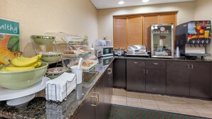 Un bufé de desayuno con diversas opciones de comida y una máquina de café.