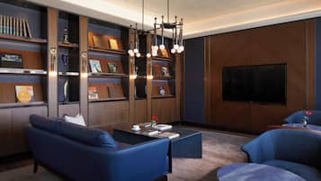 A modern living room with a blue sofa, a coffee table, and a bookshelf.