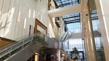 A multi-level atrium with glass railings, escalators, and indoor seating areas.